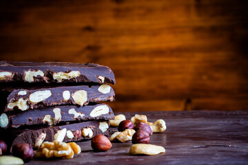 Organic food snack tasty sweet dessert milk dark chocolate bar macro closeup broken slide piece and fruit orange raspberry hazelnut nuts on cocoa cacao powder wooden table for new year Christmas gift