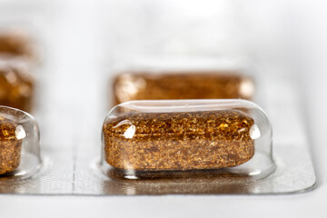 Package of brown pills close up