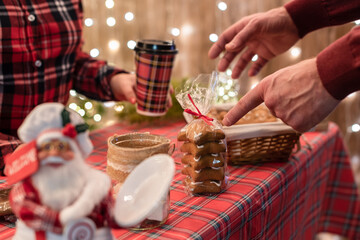 Man customer buying coffee latte in a paper cup pointing finger on gingerbread cookies at the christmas bakery.