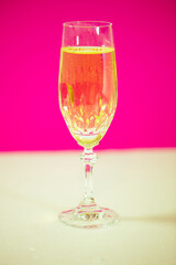 Glas Sekt, pinkfarbener Hintergrund