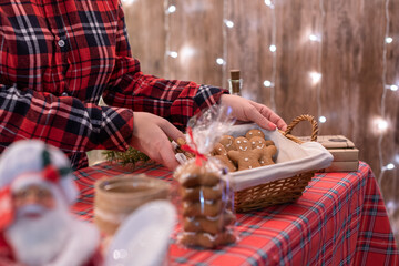 Woman seller showing a basket of gingerbread, sweets at the bakery lying in a straw basket on the counter.