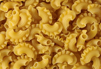 Pasta cornetti creste macaroni pile background and texture