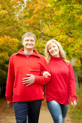 Middle-aged couple walking in the park on an autumn day.
