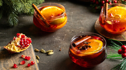 Christmas Mulled wine with different spices and fir tree bunch on rustic background. Winter time...