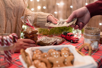 Man  customer buying christmas sweets at the bakery giving dollars to the woman seller