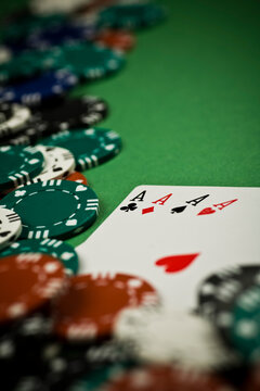 4 aces with poker chips on green background. Selective focus - shallow depth of field.