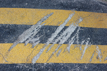 Texture and surface of scratches on concrete or pavement painted black and yellow background.