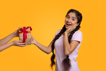 Female hands holding and giving present box to indian woman