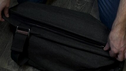Man opens and checks bag with cash money