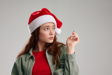 portrait of a girl in a New Year's hat and jacket on a gray background Copy Space