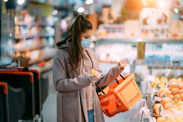 Young woman in protective mask makes purchases