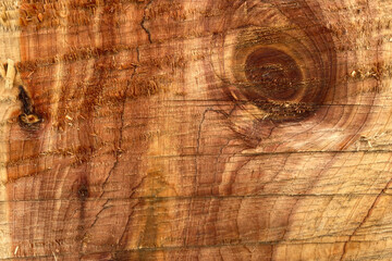 Naklejka premium Brown wooden background. A cut of natural wood. Top view. Natural raw non-planed texture timber of coniferous pine. The surface of the table to shoot flat lay in the grunge style. Copy space