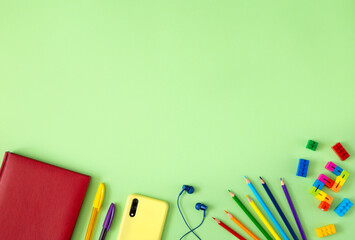 Modern childhood concept: smartphone, headphones, toys, pencils and notepad