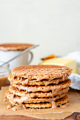 Fototapeta na wymiar Traditional local authentic Dutch Netherlands sweet fresh homemade tasty stack brown golden waffle melt salted caramel honey syrup for dessert in cafe with hot warm coffee milk tea call Stroopwafel