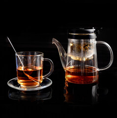 Glass teapot and mug with green tea