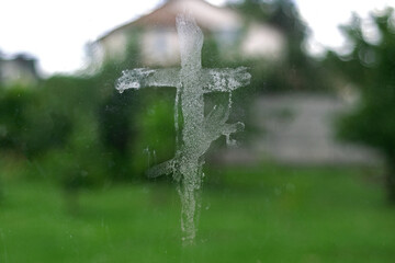 a cross painted in oil on the window as a sign of protection from the dark forces. Faith in God