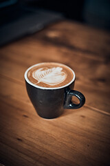 cup of hot latte art coffee on wooden table