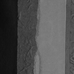 Black torn paper collage close-up. Texture made from various paper and cardboard parts. Damaged old paper background. Vintage blank wallpaper. Material design backdrop.