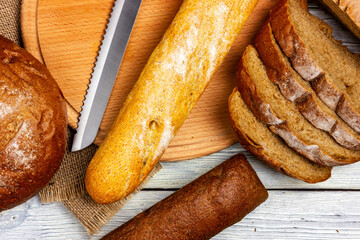 Assorted bread on a light table in Provence style. Fresh crispy toasted bread top view