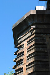 Close Up of Iron Support Straps on Old Stone Pillar seen against Blue Sky