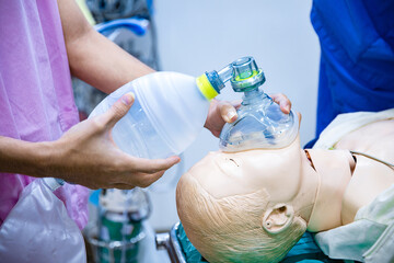 Hands holding a ambu bag on dummy patient, first aid training, CPR medical procedure