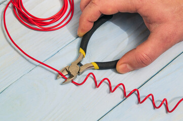 The master electrician cuts the red wire with diagonal cutting pliers. Electronics Repair Idea.