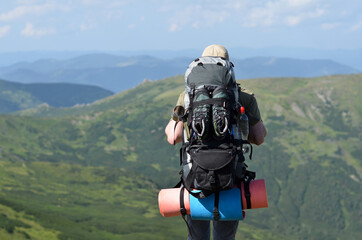 Backpacker standing over against mountains