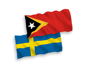 National vector fabric wave flags of Sweden and East Timor isolated on white background. 1 to 2 proportion.