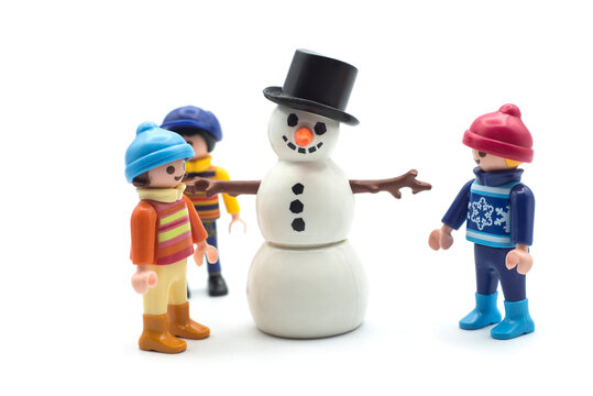 Mulhouse - France - 17 December 2020 - Closeup of playmobil kids figurines and snowman on white background