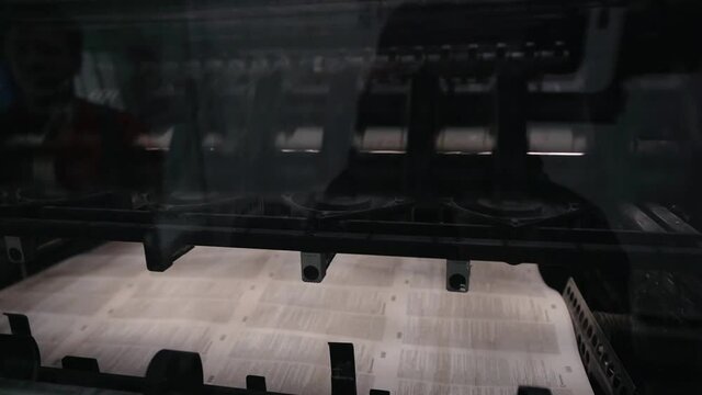 printing house machine rotates over printed newspaper. High quality FullHD footage