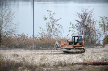 Quarry aggregate with heavy duty machinery. Caterpillar loader Excavator with backhoe driving to...