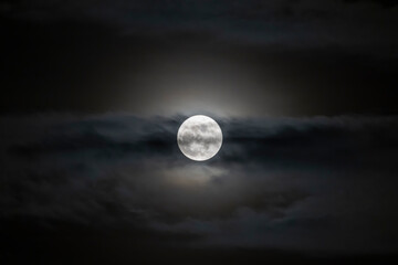 Full moon or Super moon phase with light shining in the blurred clouds for background