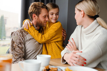 Obraz na płótnie Canvas Beautiful family talking and hugging while having breakfast at home