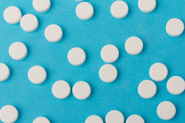 Heap of pills on blue background. Medicine, pharmacy and health concept.