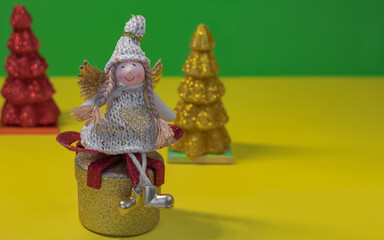Angel girl sitting on toy gift on yellow-green background