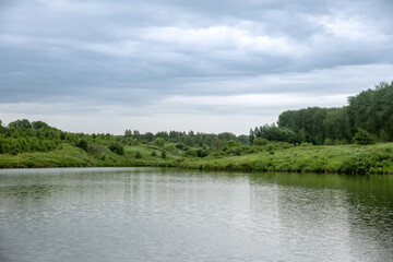Landscape with lake, forest and rain clouds.