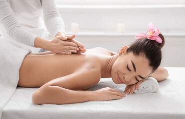 Obraz na płótnie Canvas Beautiful Asian Woman Lying On Spa Bed, Getting Back Massage Treatment