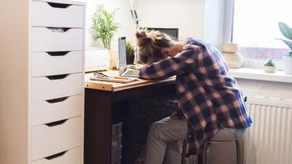 Woman is tired and asleep on the keyboard while typing email on laptop computer and lies on table. Sitting at home. Drinking coffee. Distance learning online education and work.