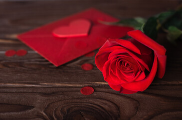 Valentines day gift card red envelop and red rose on wooden brown background, banner