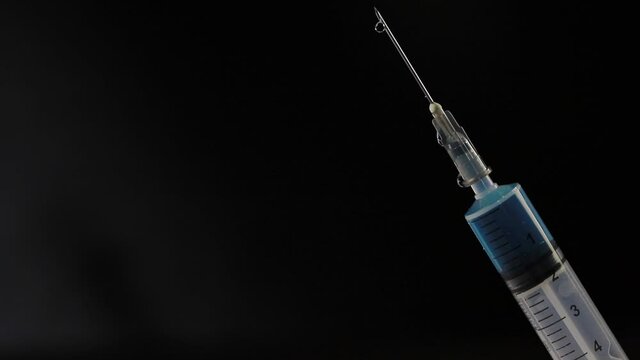 Seringa de vacina com gota escorrendo na agulha