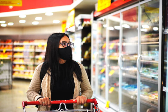 portrait of beautiful girl in glasses and mask in the supermarket, supermarket shopping concept