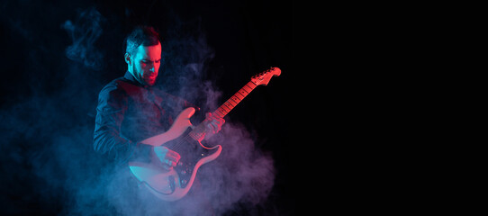 Flyer. Silhouette of young male guitarist isolated on blue-pink gradient studio background in neon. Beautiful shadow in action, performing. Concept of human emotions, expression, ad, music, art.