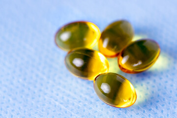 Yellow capsules of vitamin D, macro close-up of golden pills
