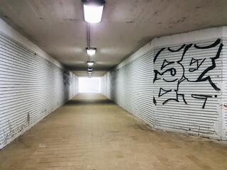 Underground walkway with graffiti on the walls.