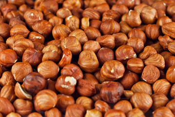 Obraz premium Peeled hazelnuts close up. Texture of nuts. Lots of nuts in a pile.