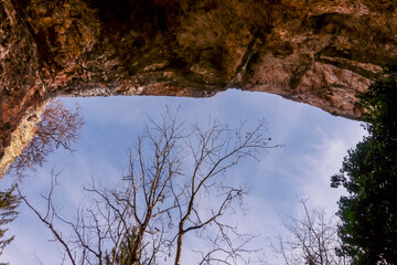 view to the sky from a cave while hiking in the mountains