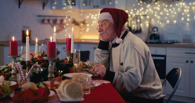 Lonely Senior Man At Festive Table For Christmas