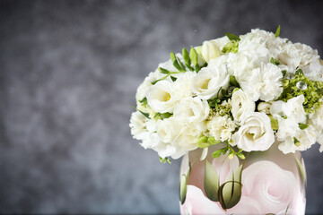 Wedding bouquet in a vase with white roses under the water drops on the mirror against grey and blue background. 