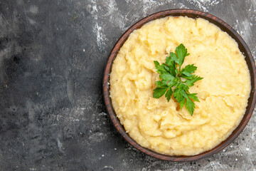top close view mashed potatoes in wooden bowl on dark background with copy space