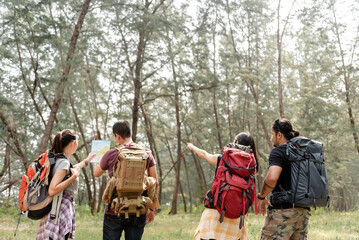 Adventure Hikers Navigating Forest Trail with Map and Backpacks for Group Exploration
